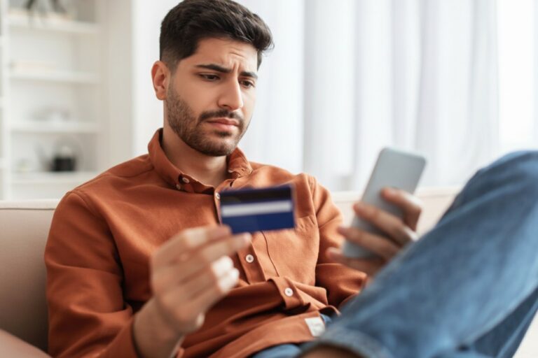 homem preocupado com dívidas e nome sujo usando o celular