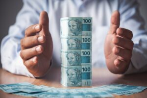 homem com notas de dinheiro empilhadas simbolizando saúde financeira