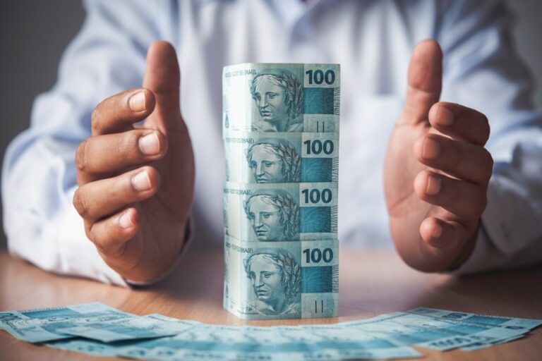 homem com notas de dinheiro empilhadas simbolizando saúde financeira